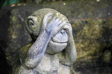 Fototapeta na wymiar Stone monkey covering his eyes similar to whats up icon