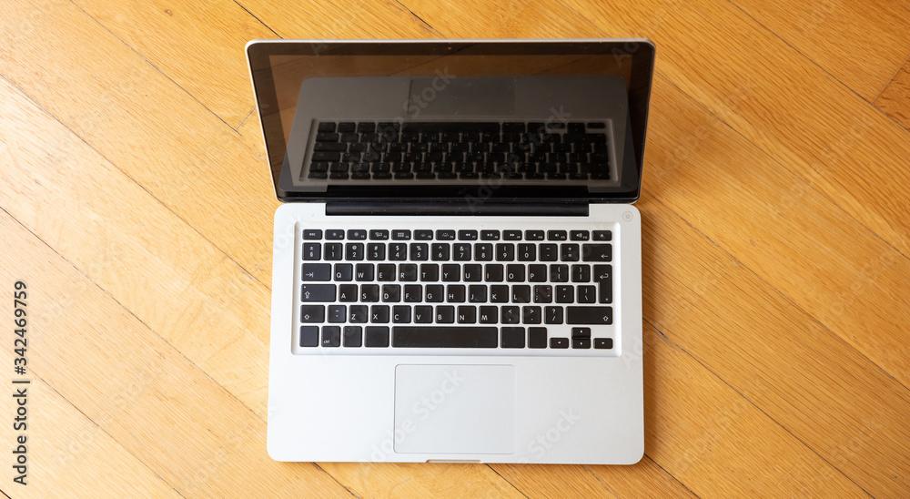 Wall mural laptop open on wooden floor, home office concept