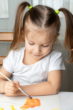 what to do to the child during the period of quarantine and self-isolation, the girl plays and draws. sitting on a chair at the table