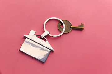 House and keys on color background, close up 