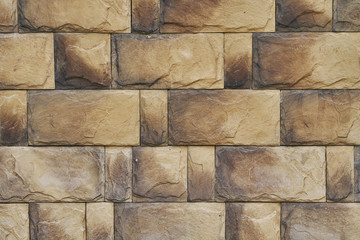 Background. Tan masonry. artificial stone cladding