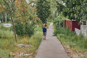 The woman in sportswear admires clusters of mountain ash