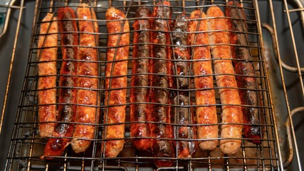 
Cooking sausage and merguez on a barbecue, close-up
