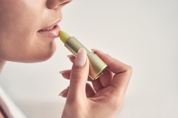 Young woman using a natural lip moisturizer