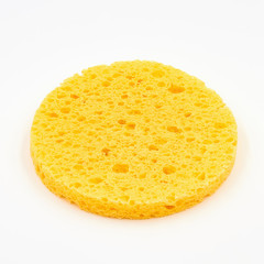 A round yellow cosmetic sponge pad for face make-up cleaning on white background