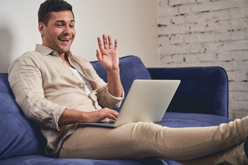 Man greeting his coworker via web camera