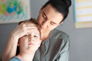 Mother touches the forehead of the child, checking the temperature