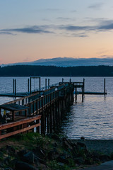 sun setting over a long fishing dock