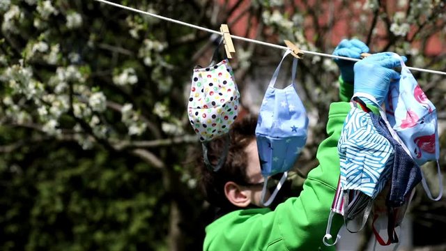 Hygienic mask hanging on the rack outdoor after being washed for cleanness and hygiene during Covid-19 virus outbreak. Drying mask hanging under the sun after use for disinfecting