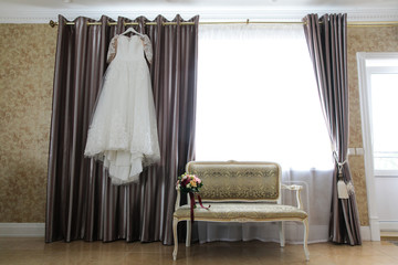 wedding dress hanging on a cornice
