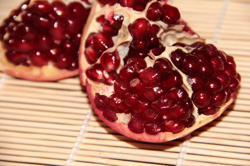 Pomegranate berries on a beige wooden background. Pomegranate.