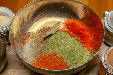 Ground spices in a bowl with bay leaf