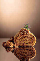 Walnut cake on a reflective background.