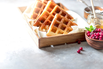 Gluten-free homemade waffles on a light gray concrete background.