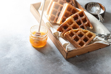 Gluten-free homemade waffles on a light gray concrete background.