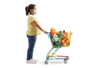 Girl standing with a shopping cart and wearing a medical face mask