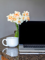 work from home with laptop coffee and flowers