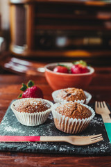 Appetizing Chocolate Muffins made with wholemeal flour and brown sugar with strawberries for a healthy breakfast.