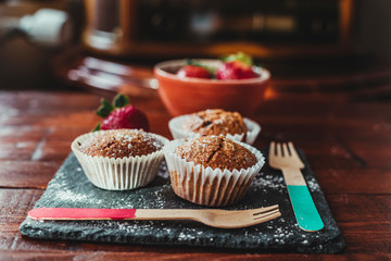 Appetizing Chocolate Muffins made with wholemeal flour and brown sugar with strawberries for a healthy breakfast.