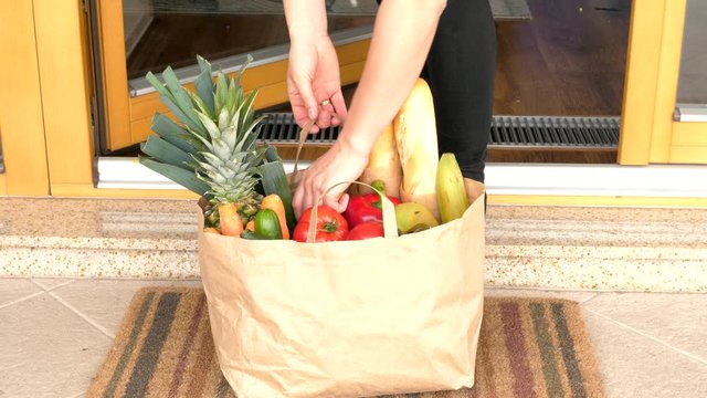 Taking Grocery Bag With Fresh Fruits From Under The Door Food Delivery