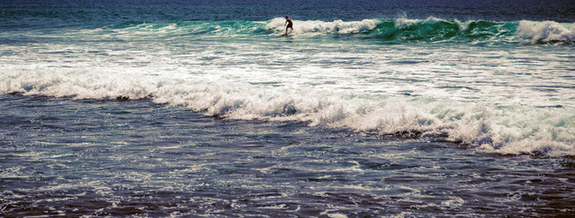 Silhouette surfer people rides surfboard blue sea water with white foam for background