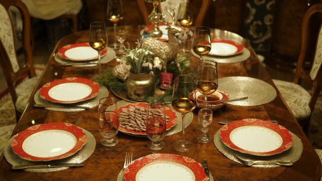 Table setting served. Christmas dinner living room family house. Festive decor candles, pine. Top view.