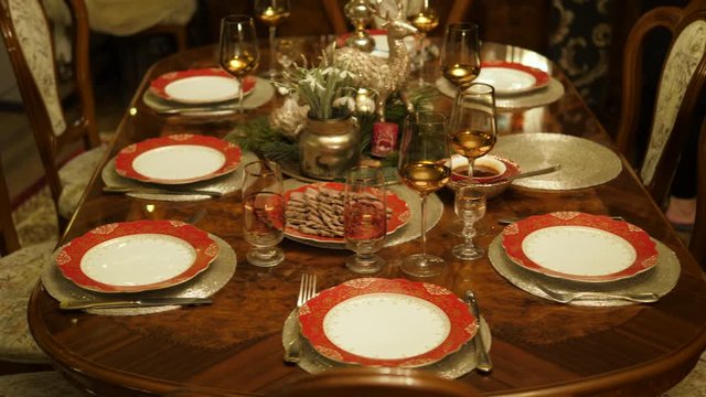 Table setting served. Christmas dinner living room family house. Festive decor candles, pine. Top view.