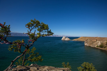 Lake Baikal. Rock Shaman. Beautiful autumn landscape of Lake Baikal with bright saturated sky, blue water.