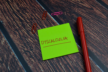Dyscalculia write on a sticky note Isolated on wooden table background