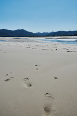 Peaceful calm empty beach at Koh Yao Noi Island, Thailand at midday with human steps.