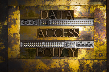 Photo of real authentic typeset letters forming Data Access Policy text bordered by harddrive port connections on vintage textured grunge copper and gold background