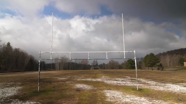 Football uprights with empty football field. Paint peeling. Off season. Ontario, Canada.