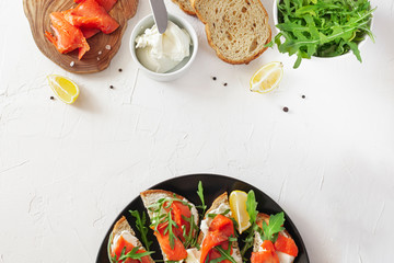 Salmon sandwich on a plate and ingredients for cooking
