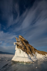 Lake Baikal. Ogoy Island. Rocky island in ice on a sunny day. Transparent ice of Baikal
