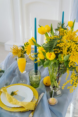Breakfast at the table with fresh flowers. Mimosa and lemons on the table
