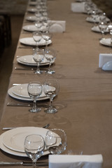 The served table in the restaurant. Clean dishes and appliances on the tablecloth in a cafe. Shiny transparent glasses. White plates. Prepared for the reception of guests. High service.