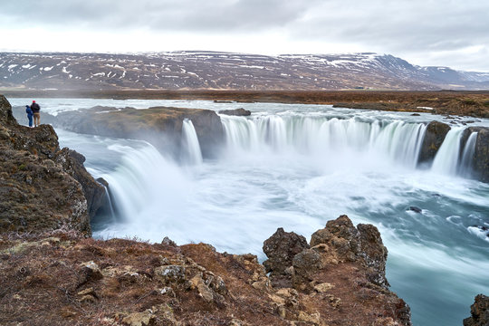 Two People Standing Above Godafoss Waterfall at Iceland © Andreas