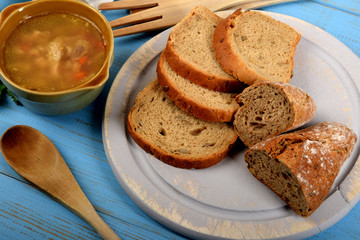 tripe soup in a small brown bowl next to dry bread