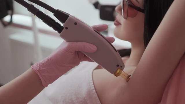 Woman having underarm Laser hair removal epilation. Laser treatment in cosmetic salon