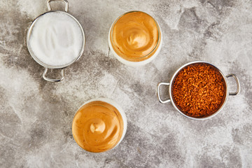 Obraz na płótnie Canvas Iced Dalgona Coffee, a cool trendy fluffy whipped creamy coffee. Latte espresso with coffee foam in tall glass and milk.