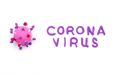 Abstarct virus model of the coronavirus 2019-nCoV and the inscription CORONAVIRUS made of air colored children's pink and purple plasticine on the white background.World coronavirus pandemic concept