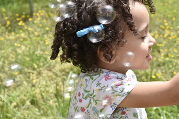little girl blowing bubbles