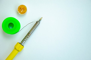 Soldering iron, tin, rosin on a white background. Soldering iron in male hands. Macro. Repair of...