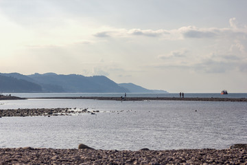 morning, sea beach of pebbles with a bay on a background of mountains