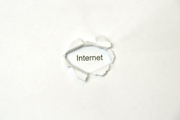 Word internet on white isolated background, the inscription through the wound hole in the paper. Stock photo for web and print with empty space for text and design.