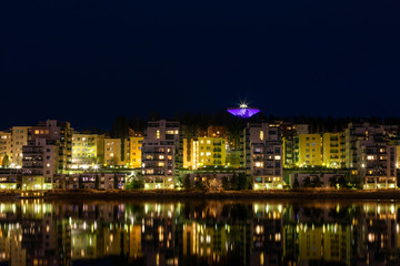 Fototapeta na wymiar Waterfront residential buildings, still water and water reflections in Jyväskylä