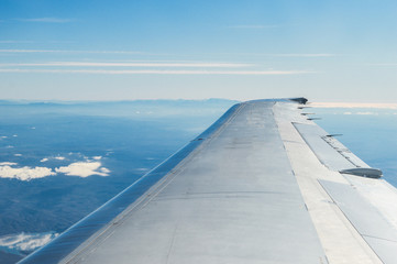 Fototapeta na wymiar beautiful clouds, sky and mountains through the airplane window