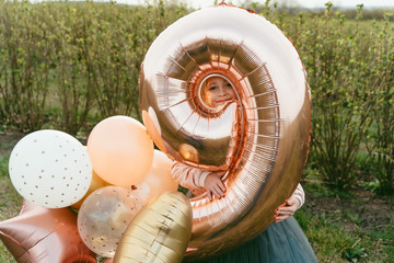 little princess in a luxurious dress and with balloons