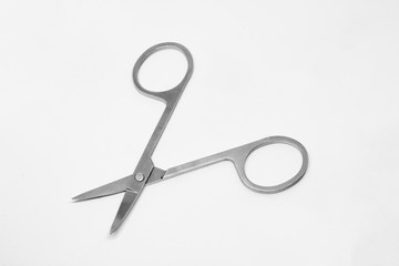 Gray metal manicure scissors in the unfolded state on a white background