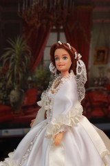 Naklejka premium A small beautiful child's doll, posing in beautiful places. Queen. 